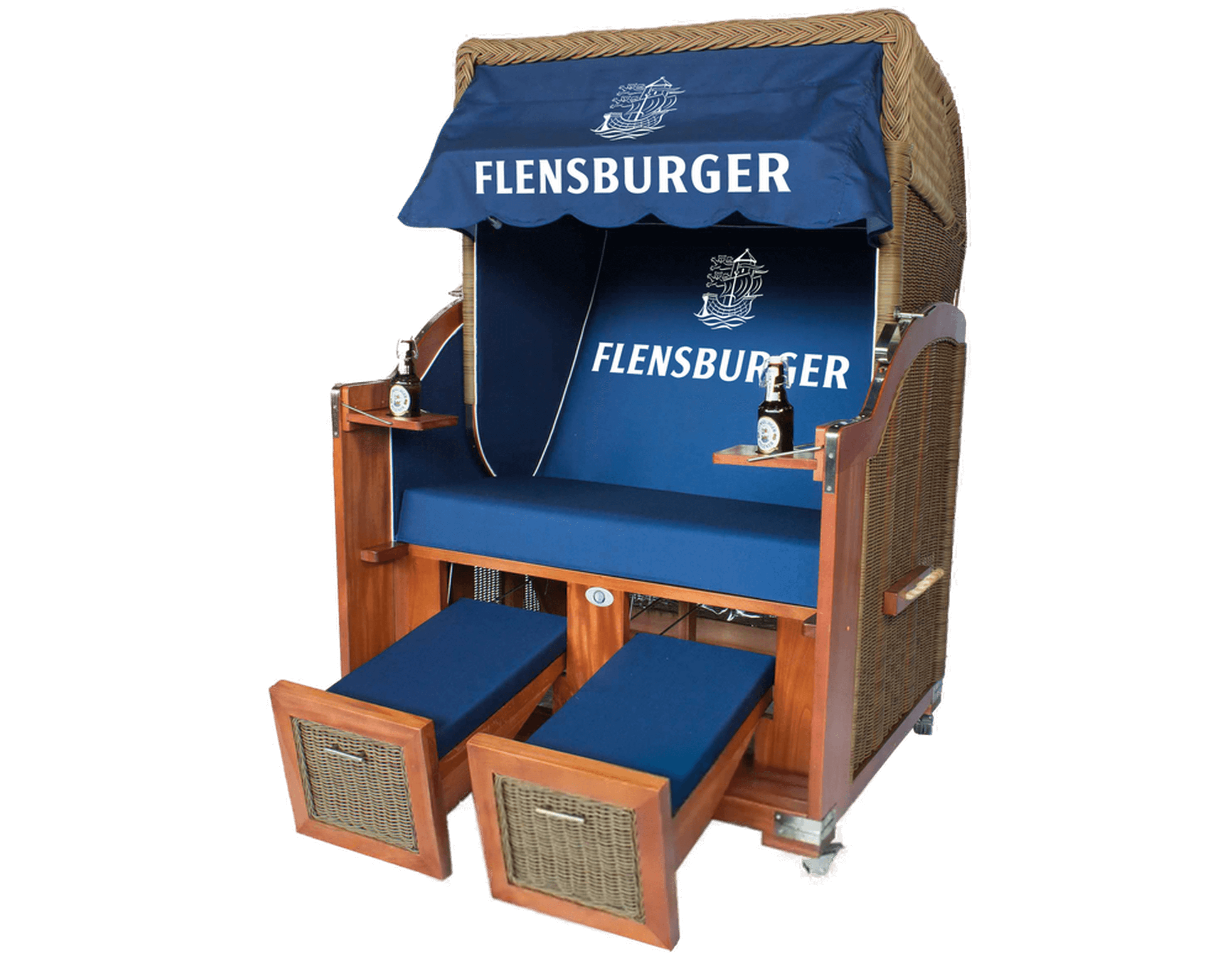 Strandkorb „Hörnum“ mit blauem Polster und Markisenstoff, auf dem „FLENSBURGER“ in Weiß steht. Er verfügt über zwei gepolsterte Fußablagen, zwei kleine Tische mit Flaschenhaltern und ist aus Mahagoni-Holz und Geflecht gefertigt.