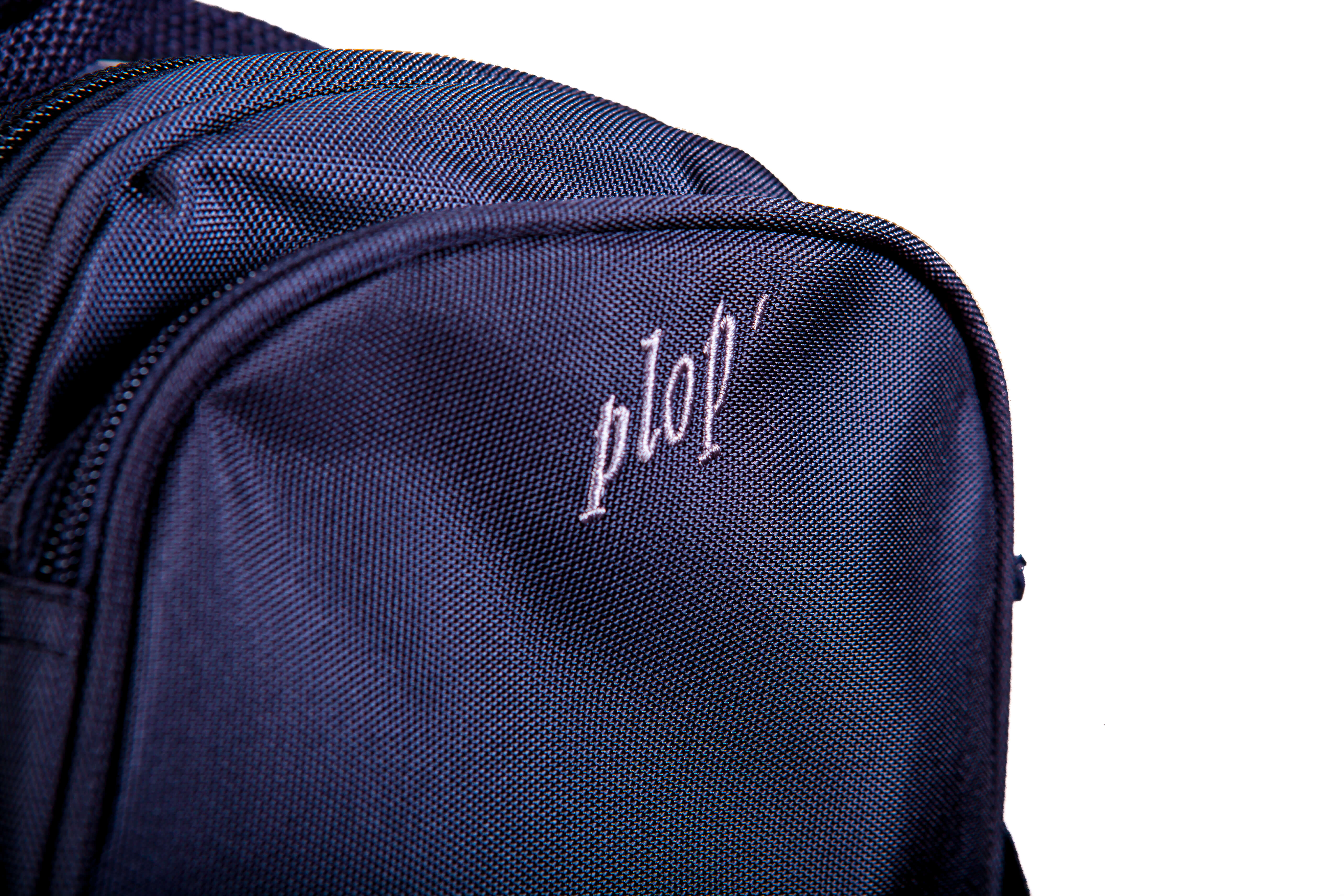 Detailansicht: Navyblaue Kulturtasche aus Polyester mit der weißen Stickerei "ptop" auf der Vorderseite. Sie hat eine sichtbare Naht und einen Reißverschluss.